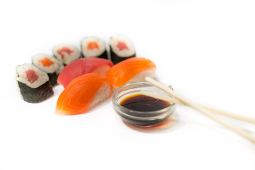 Sushi rolls and nigiri with chopsticks and soy sauce on a white background