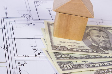 House of wooden blocks and currencies dollar on construction drawing, building house concept
