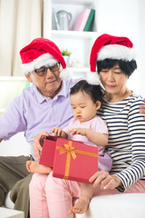 asian grand parents with grand daugther celebrating christmas