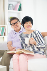 Fototapeta premium senior asian couple reading a book together at home.