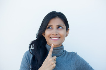 Closeup portrait, charming upbeat smiling joyful happy young woman looking upwards daydreaming something nice, isolated white wall background. Positive human emotions facial expressions feelings