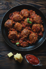 Frying pan with meatballs in tomato sauce, view from above