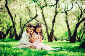 two happy dressy girls playing on spring walk, outdoor activities, friendship concept