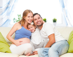 happy family. pregnant mother, father, and child daughter at hom