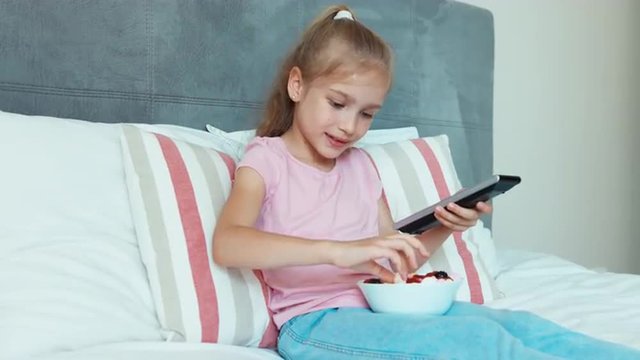 Girl watches TV and eating sweets