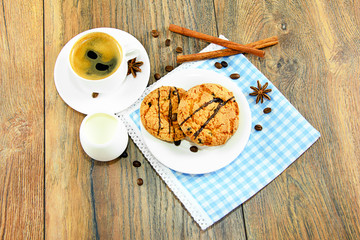 Cookies, coffee and cream on woody background