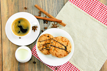 Cookies, coffee and cream on woody background