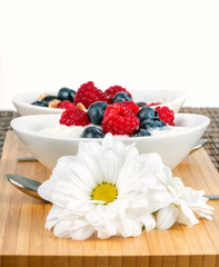 Healthy eating.
Bowl with berries and yoghurt on a bamboo mat close up.