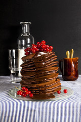 stack of pancakes on the tablecloth chocolate and fresh currants