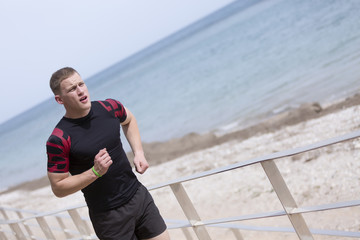 male runner running on the beach