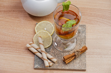Fototapeta na wymiar Tea with lemon, cinnamon sticks, tangerine