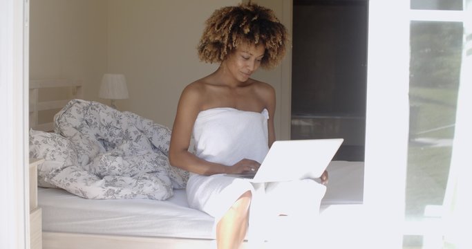 Young Woman Using Laptop On Bed