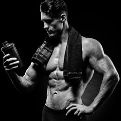 Muscular fitness male bodybuilder holding protein shake bottle r