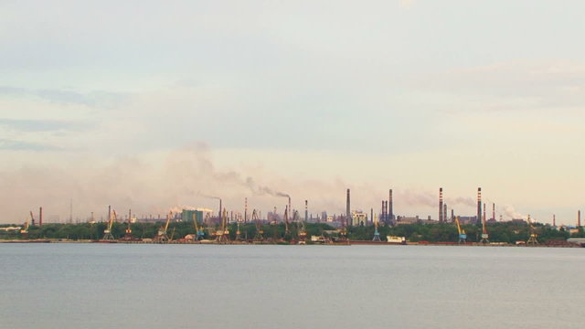 Calm Riverscape With Industrial Factory Against Grey Sky