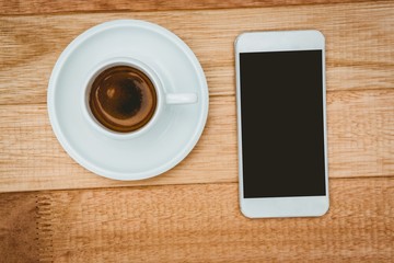 Obraz na płótnie Canvas Above view of a coffee and a smartphone