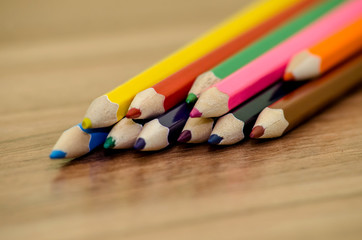 Blank paper and colorful pencils on the wooden table