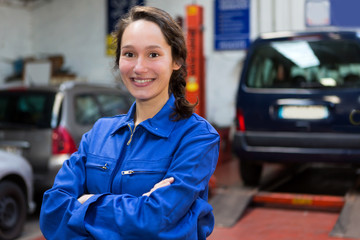 Fototapeta Young attractive woman mechanic working at the garage obraz