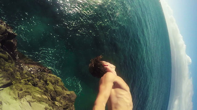 POV Slow Motion Cliff GOPRO Selfie Stick Jumping Backflip. Athletic Young Man Jumping From Cliff Into Ocean. Adventure Extreme Sports Lifestyle Hobby Vacation