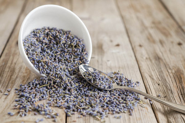  a white cup of dried lavender with stainless tea spoon