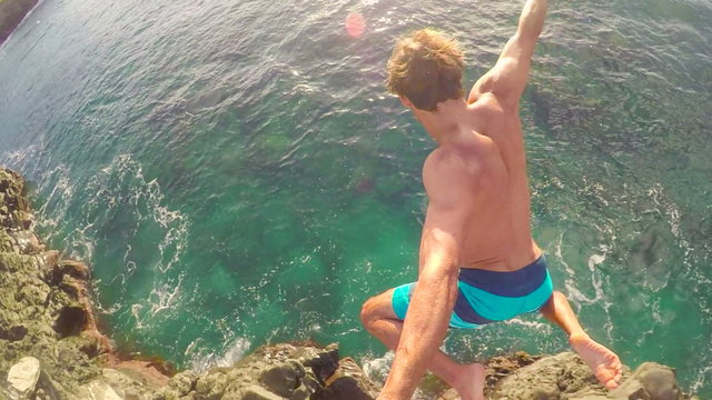 POV Slow Motion GOPRO Selfie Stick Cliff Jumping. Athletic Young Man Jumping From Cliff Into Ocean. Adventure Extreme Sports Lifestyle Hobby Vacation