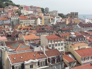 Fototapeta na wymiar Blick über die Dächer der Baixa (Unterstadt) hinauf zur Alfama mit der Kathedrale von Lissabon und dem Rio Tejo im Hintergrund