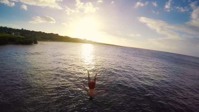 Slow Motion Sunset Cliff Jumping Backflip. Athletic Young Man Jumping From Cliff Into Ocean. Adventure Extreme Sports Lifestyle Hobby Vacation