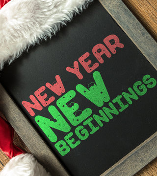 New Year New Beginnings written on blackboard with santa hat