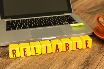 Reliable written on a wooden cube in a office desk