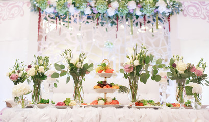 Flowers bouquet in vase on the table. Wedding decoration, decor. Holiday decoration flowers.