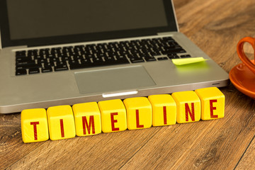Timeline written on a wooden cube in a office desk