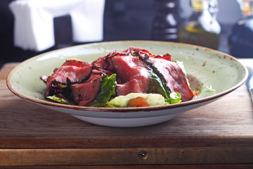 salad of meat on a plate, cut into thin slices