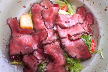 salad of meat on a plate, cut into thin slices