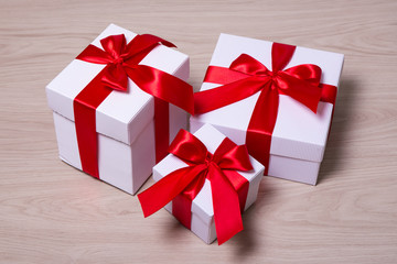 Fototapeta premium gift boxes with red ribbon on wooden background