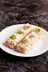 oat bar with coconut with mint on a plate, close up