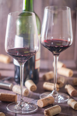 Red wine glasses, bottle and corks