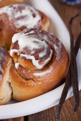 Homemade glazed cinnabons with cinnamon and almonds, american kitchen. Closeup.