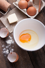 Ingredients and tools ready to make a cake, flour, eggs, butter, cinnamon stick on a wooden table