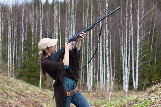 Woman hunter  takes aim from a gun