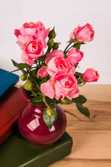 Pink rose on wooden table background with retro glasses and white hand made paper as a copy space, Romantic floral theme