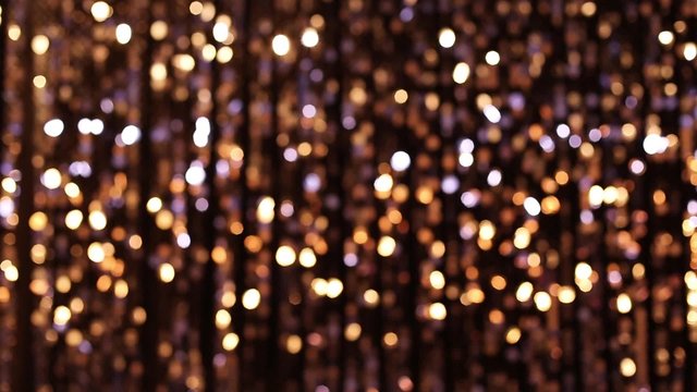 Abstract glittering lights, gold background, a real shot video in the blur