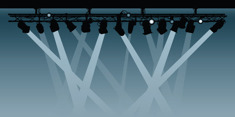 A background silhouette illustration of a spotlight rig shining beams down into the darkness.