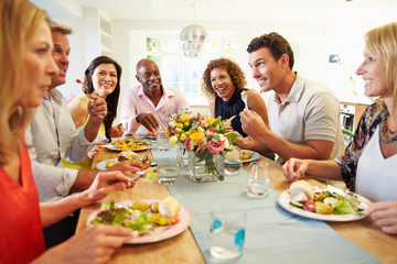 Mature Friends Sitting Around Table At Dinner Party