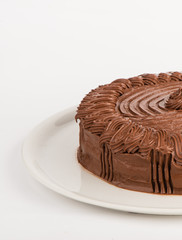 Homemade cake with black chocolate served on a white plate. Studio shot on white background