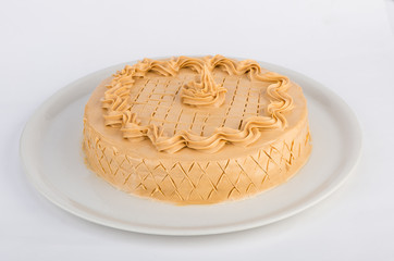Homemade cake with hazelnut and peanuts served on a white plate. Studio shot on white background