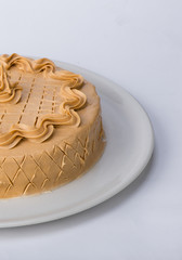 Homemade cake with hazelnut and peanuts served on a white plate. Studio shot on white background