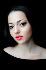 Fototapeta na wymiar Portrait of beautifull brunette woman with red earrings on black background