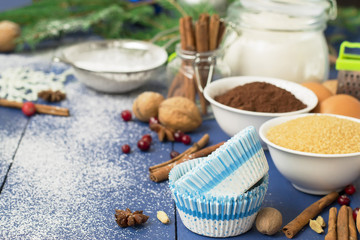 Ingredients for baking Christmas muffins on wooden background. s