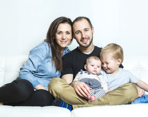 Young happy family with two children at home