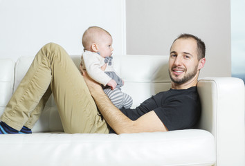 Fototapeta premium Father with baby on the sofa taking good time