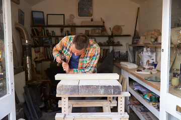 Stone Mason At Work On Carving In Studio